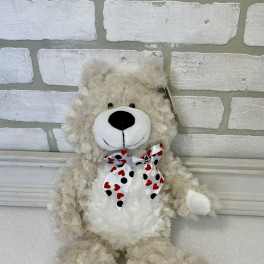 Plush teddy bear with a heart-patterned bow tie