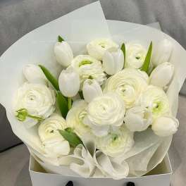 White tulips and ranunculus in white wrapping paper