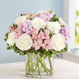 Bouquet of white roses and pink flowers in a clear glass vase
