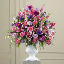 Large bouquet of pink, purple, and white flowers in a white vase