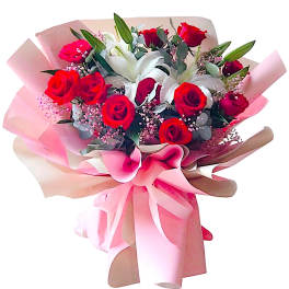 Bouquet of red roses and white lilies wrapped in pink paper