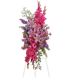 Tall pink and purple floral standing spray on a white easel