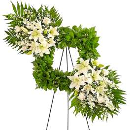 White floral wreath on a black easel stand