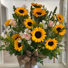 Sunflower bouquet with pink roses in a silver vase