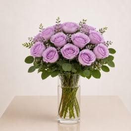 Lavender roses arranged in a clear glass vase