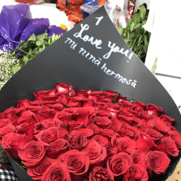 Large bouquet of red roses wrapped in black paper