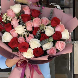 Large bouquet of red, pink, and white roses wrapped in pink paper