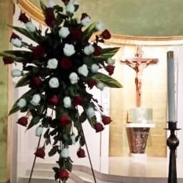 Tall floral spray with red and white roses on a stand