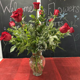 Red roses arranged in a clear glass vase