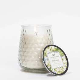White candle in a textured glass jar with a matching lid