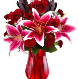 Red roses and pink lilies in a red glass vase