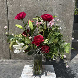 Mixed bouquet of red roses and white lilies in a clear glass vase