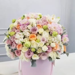 Pastel rose bouquet in a pink hatbox with ribbon handles