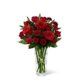 Red roses and carnations in a clear glass vase