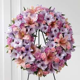 Lavender and pink floral wreath on a black stand