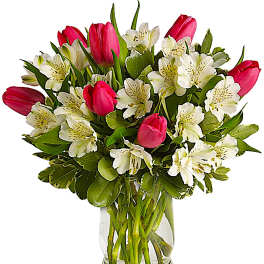 Pink tulips and white alstroemeria in a clear glass vase