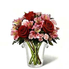 Red and pink flower bouquet in a clear glass vase