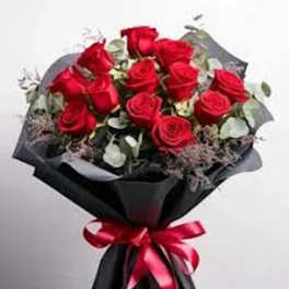 Bouquet of red roses wrapped in black paper with a red ribbon