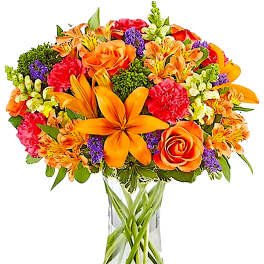 Bright mixed bouquet with orange lilies and roses in a clear glass vase