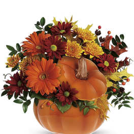 Pumpkin-shaped floral arrangement with orange and burgundy flowers
