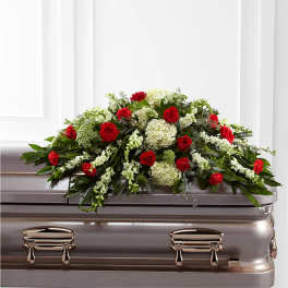 Red roses and white flowers arranged on a casket