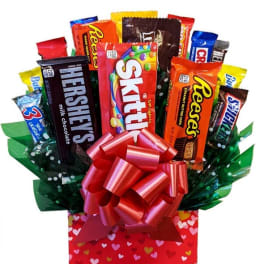 Candy bouquet in a red heart-patterned box with a large pink bow