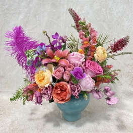 Colorful mixed flower arrangement in a blue vase