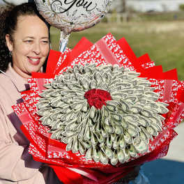 Woman holding a bouquet made of folded dollar bills and red wrapping