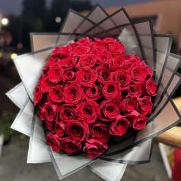 Bouquet of red roses wrapped in translucent black and white paper
