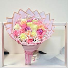 Pink and yellow rose bouquet wrapped in pastel paper