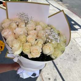 Bouquet of cream roses with baby's breath in white wrap