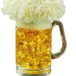 White flowers arranged in a beer mug filled with amber liquid
