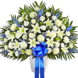 White lilies and roses in a vase with a blue ribbon