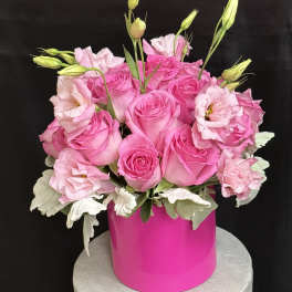 Pink roses and lisianthus arranged in a bright pink vase