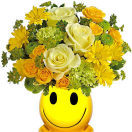 Yellow and white flower arrangement in a smiley-face vase