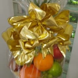 Gift basket of assorted fresh fruit wrapped in cellophane with a large gold bow