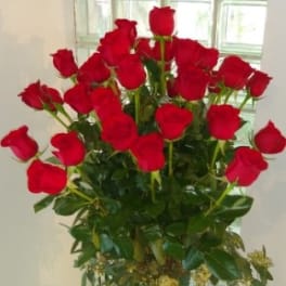Tall bouquet of red roses in a glass vase