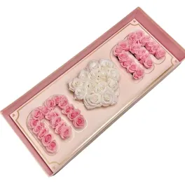 Pink and white rose arrangement shaped like the word "MOM" in a gift box
