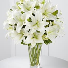 White lilies arranged in a clear glass vase