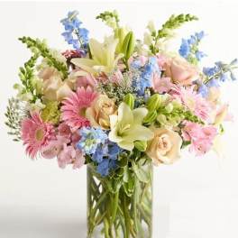 Mixed bouquet of pastel flowers in a clear glass vase