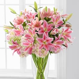 Pink lilies arranged in a clear glass vase