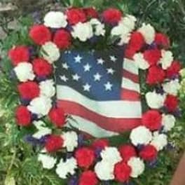 Red, white, and blue floral wreath around an American flag