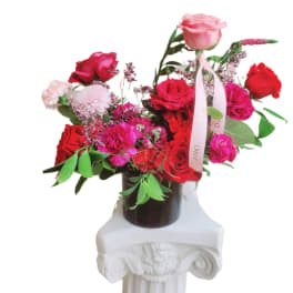 Bouquet of red and pink roses in a dark vase