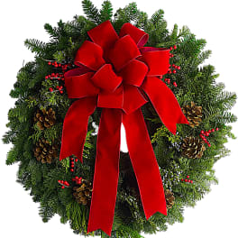 Christmas wreath with a red bow, pinecones, and red berries