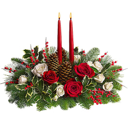 Holiday centerpiece with red candles, roses, pinecones, and evergreen branches