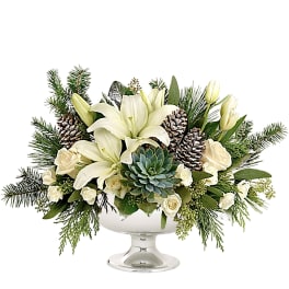 White lilies and roses in a glass pedestal bowl with pinecones