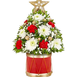 Christmas tree-shaped floral arrangement in a red drum container