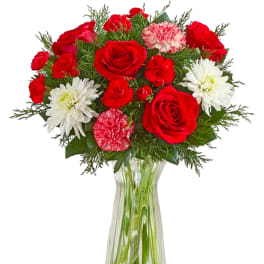 Red roses and white daisies in a clear glass vase