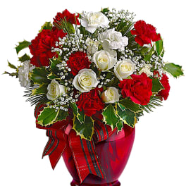 Red and white roses in a red glass vase with a ribbon