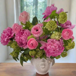 Pink flowers arranged in a sculpted face vase
